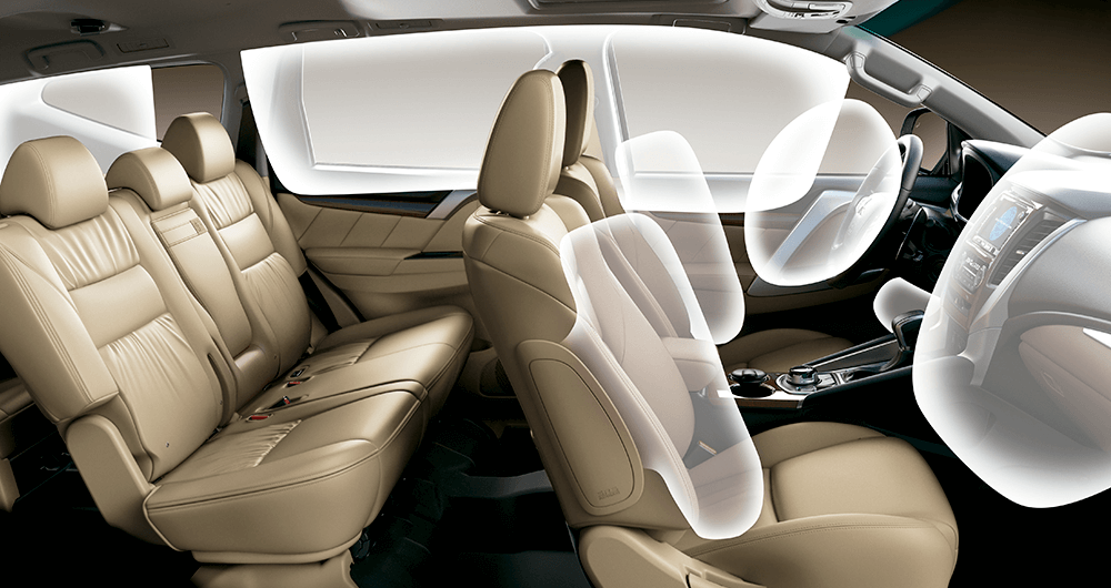 Interior del Mitsubishi Montero Sport mostrando tres filas de asientos beige con airbags desplegados
