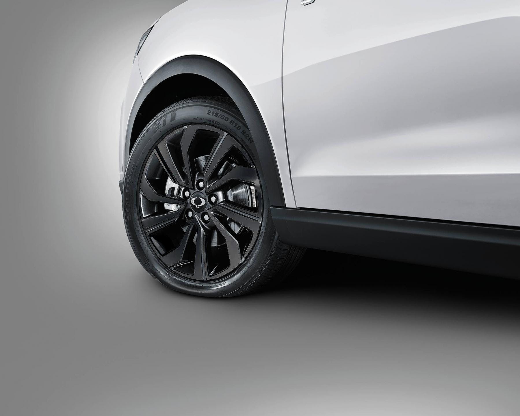 Aro deportivo negro de 18 pulgadas con logo SsangYong en SUV blanco