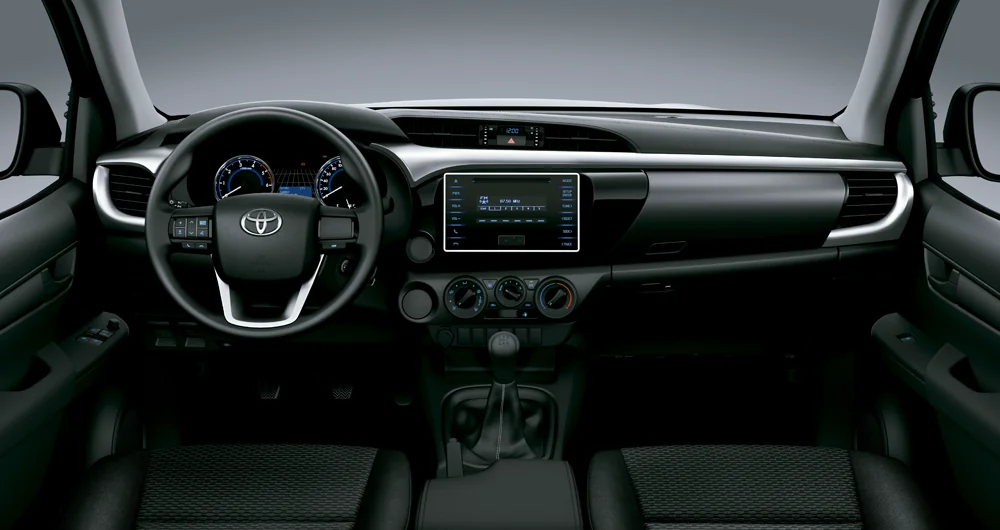 Tablero interior de Toyota Hilux con volante, pantalla multimedia y transmisión manual