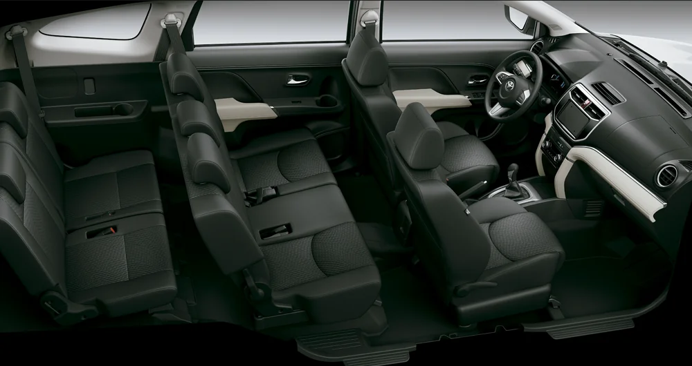 Interior de camioneta Toyota con tres filas de asientos negros y volante al frente
