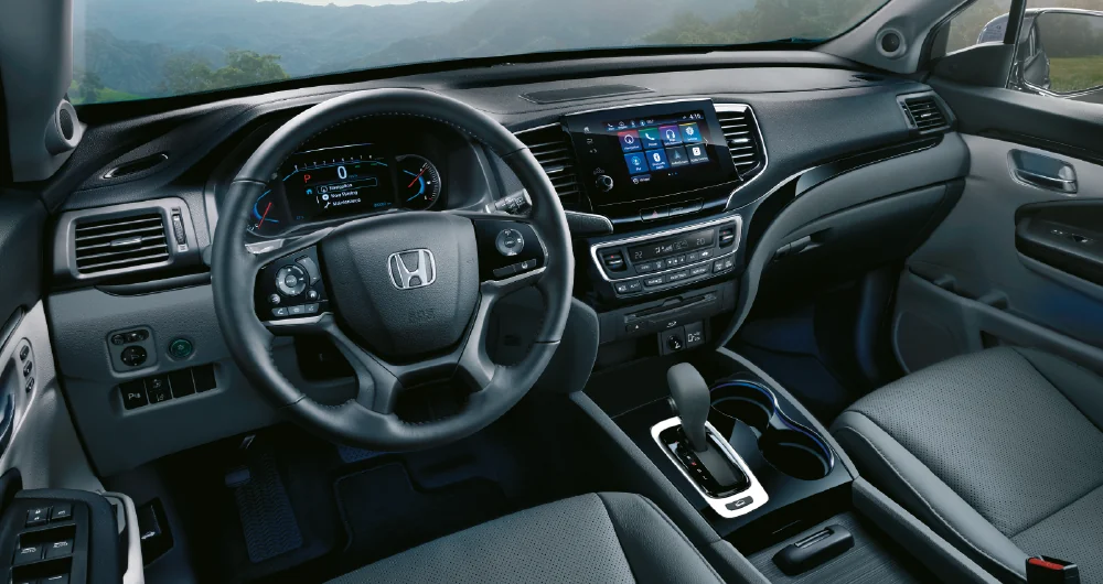 Interior del Honda Pilot con volante logo Honda pantalla táctil central y palanca de cambios automática