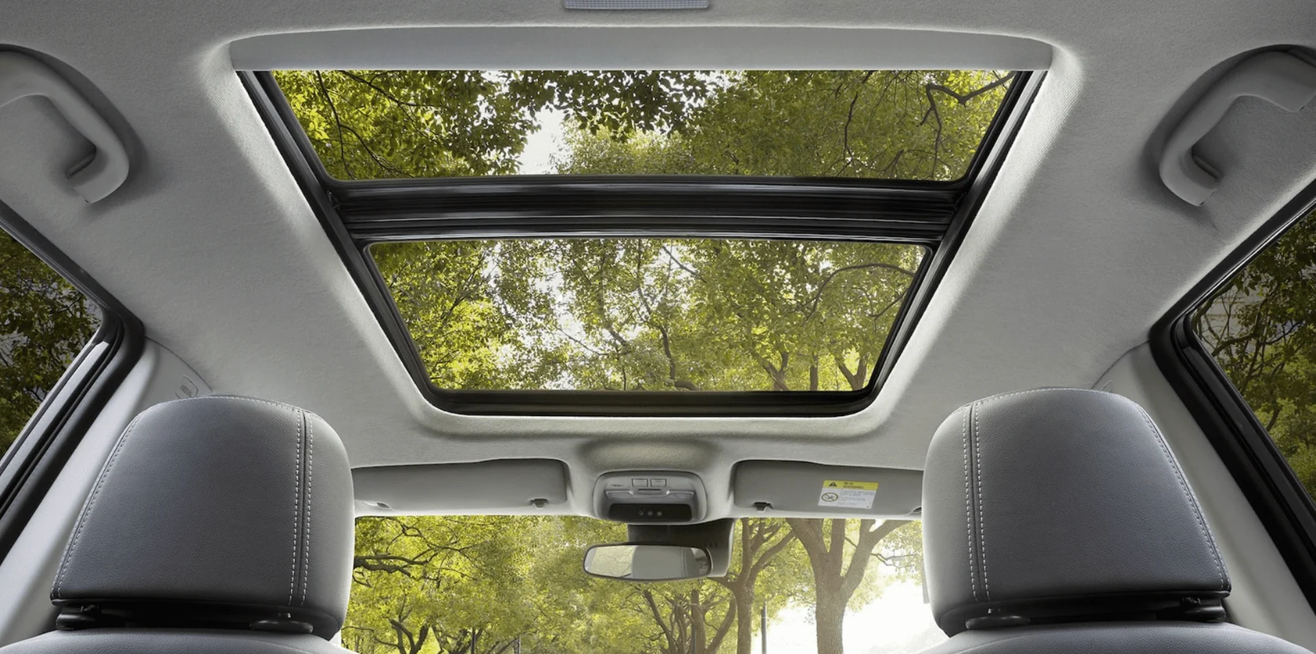Techo panorámico corredizo del Chevrolet Tracker con vista a árboles verdes desde el interior