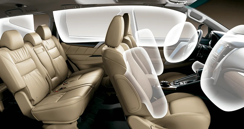 Interior del Mitsubishi Montero Sport mostrando tres filas de asientos beige con airbags desplegados