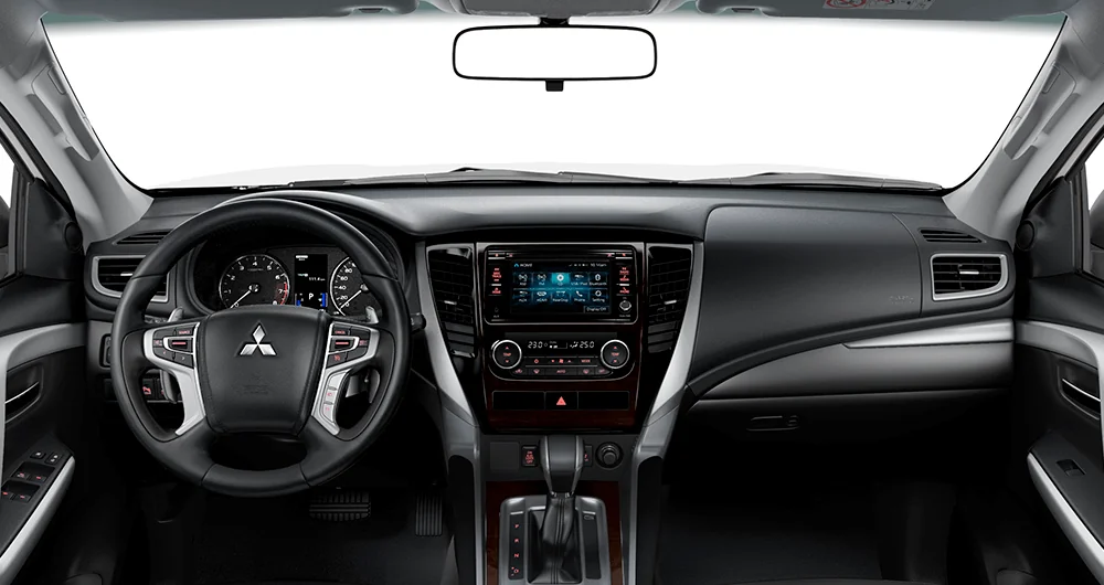 Interior del Mitsubishi Montero Sport con volante, tablero y pantalla táctil central en negro
