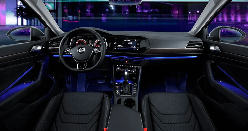 Interior del Volkswagen Jetta con iluminación ambiental azul, volante y palanca automática