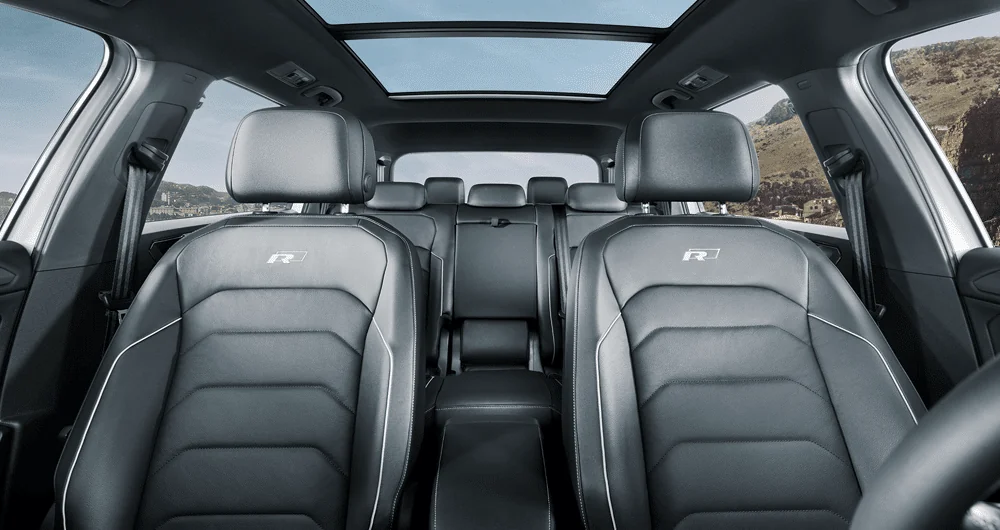 Interior trasero del Volkswagen Tiguan Allspace con asientos negros R-Line y techo panorámico