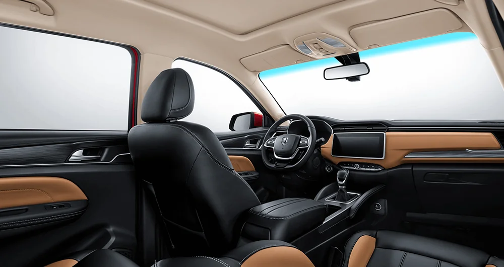 Interior del Jinbei Konect con asientos de cuero negro y caramelo, volante y pantalla central, techo panorámico abierto