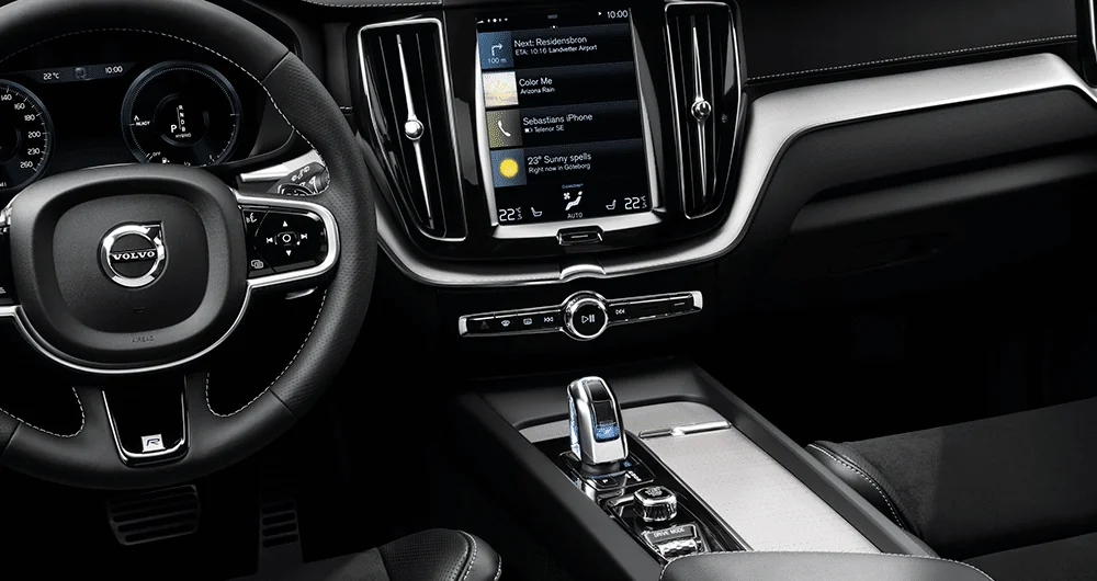 Interior del Volvo XC60 con volante, pantalla táctil central y palanca de cambios iluminada