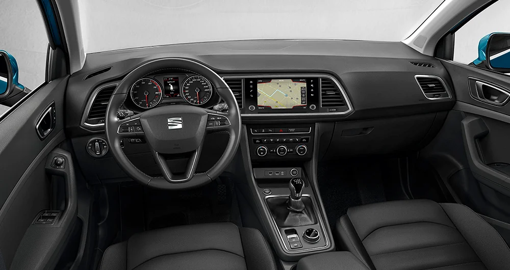 Interior del SEAT Ateca con tablero oscuro, volante con logo SEAT, pantalla de navegación y palanca de cambios
