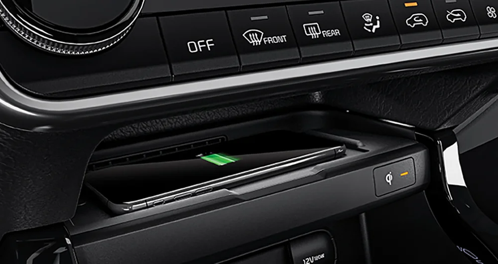 Consola central del Kia Seltos con cargador inalámbrico Qi activo, puerto USB y toma de 12V empotrada