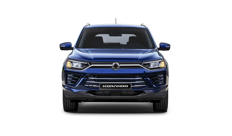 SUV SsangYong Korando azul vista frontal directa con faros LED encendidos y logo central en parrilla