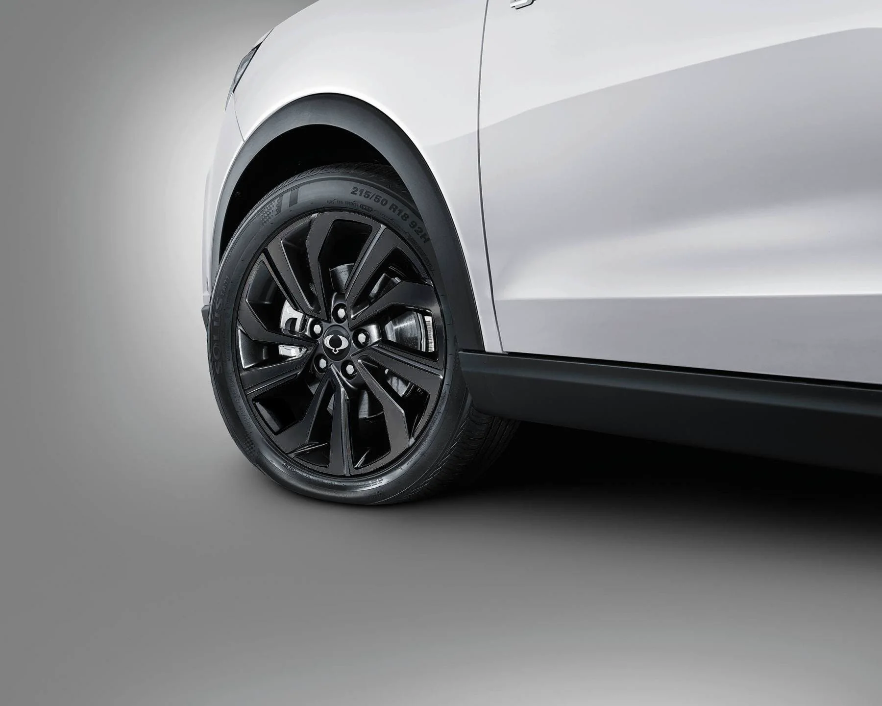 Aro deportivo negro de 18 pulgadas con logo SsangYong en SUV blanco