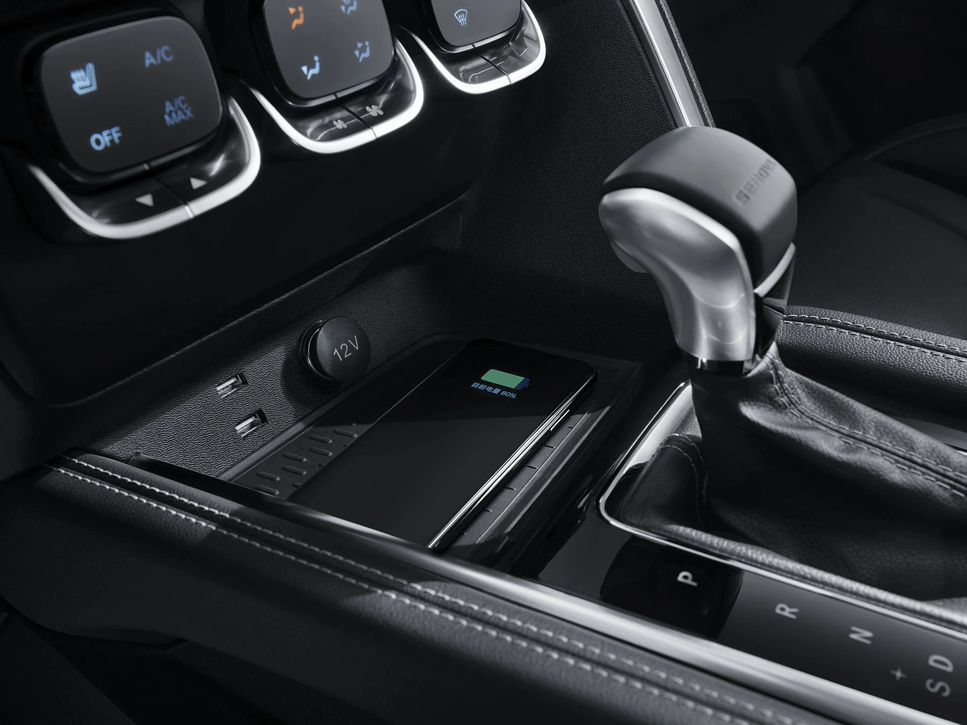 Interior de auto con consola central negra, cargador inalámbrico con smartphone, palanca automática y controles de aire acondicionado