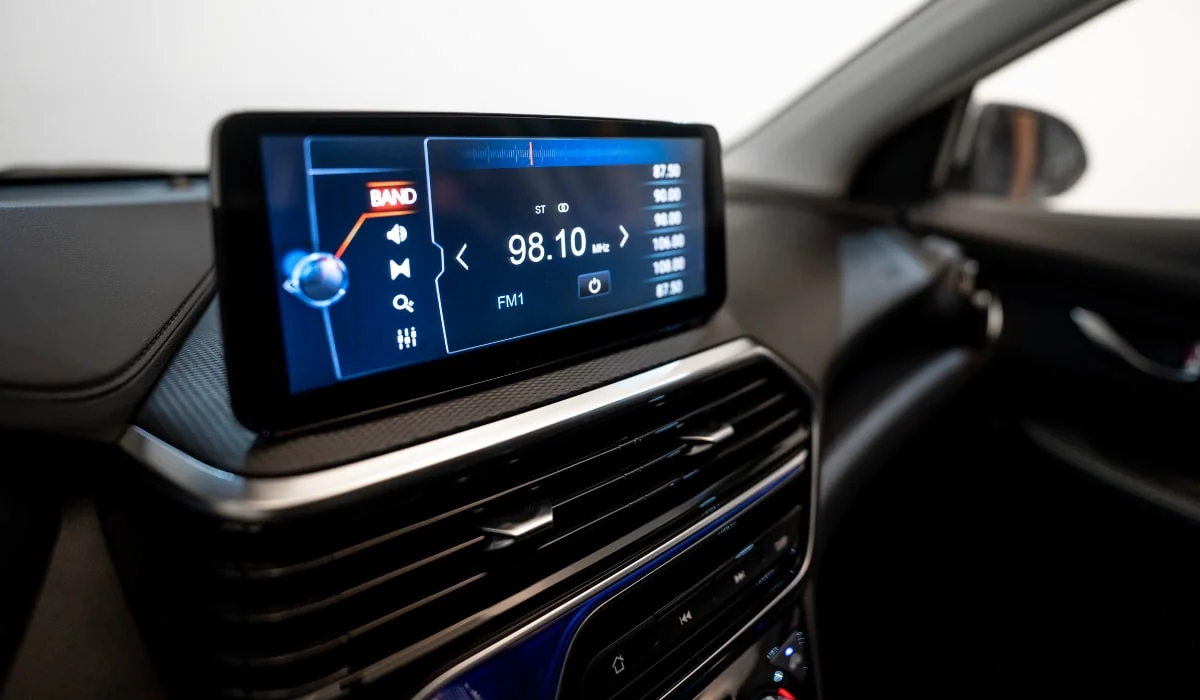 Pantalla multimedia de auto Changan mostrando radio FM en consola central con rejillas de ventilación