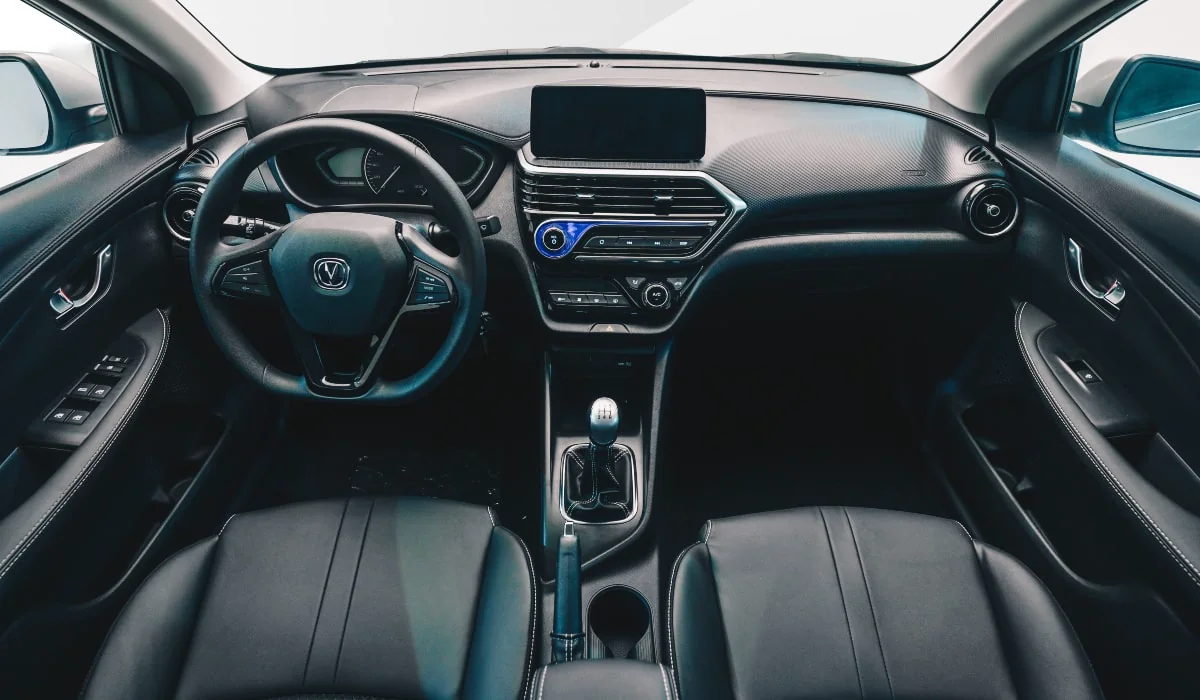 Interior del Changan con tablero negro, pantalla táctil, volante y palanca de cambios manual