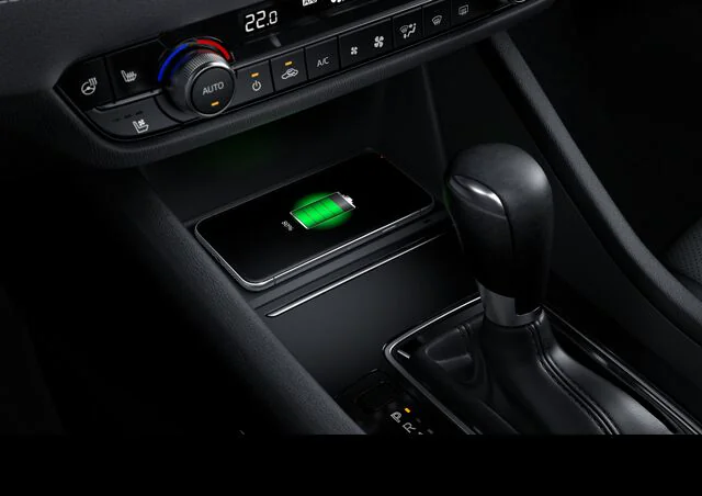 Consola central del Mazda 6 con cargador inalámbrico Qi activo mostrando un smartphone cargando, junto a la palanca de cambios