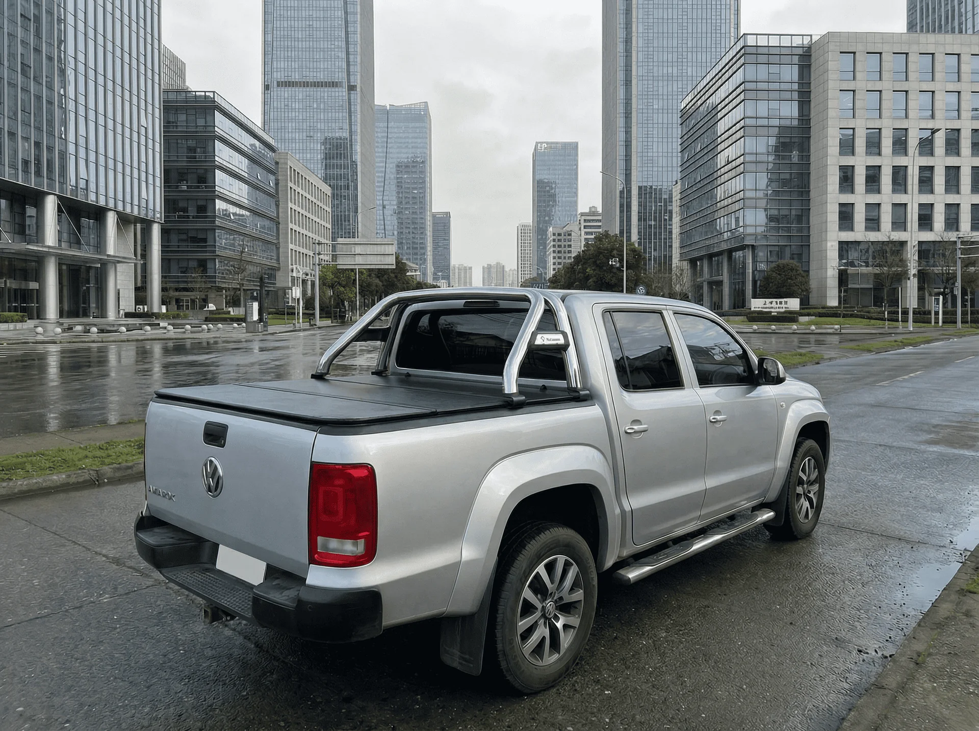 Camioneta pickup Volkswagen Amarok plateada estacionada en zona urbana con edificios corporativos